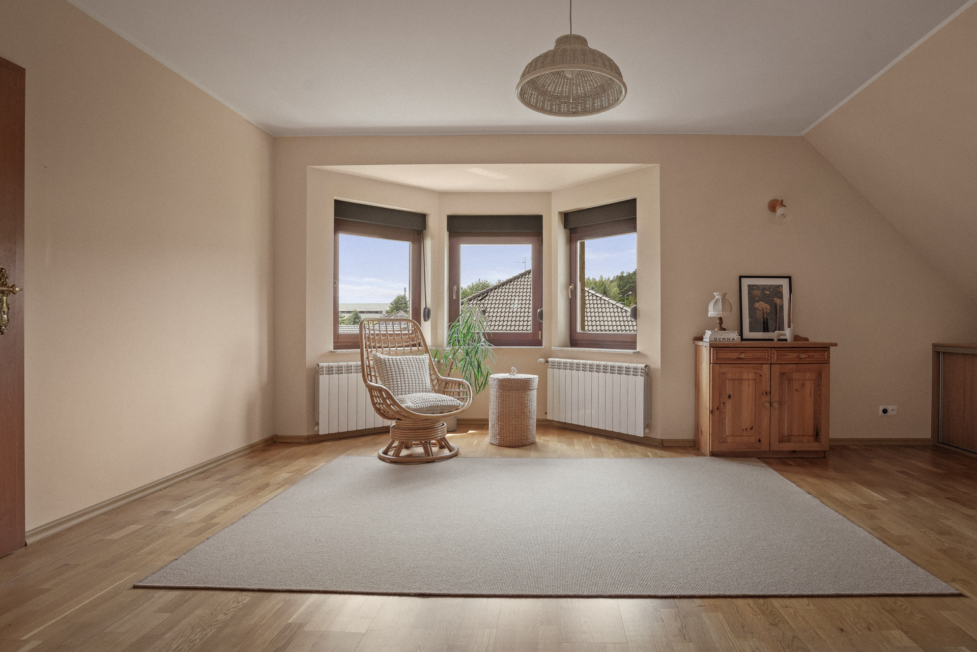 pokój po home staging Poznań, w którym stoi fotel, roślina, jest jasny i przestronny